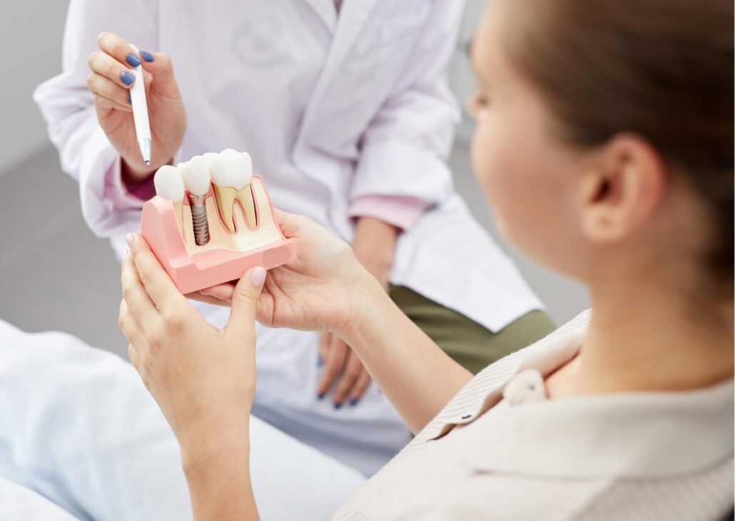 Dentist explaining a dental implant model during a consultation about dental implant costs and treatment planning
