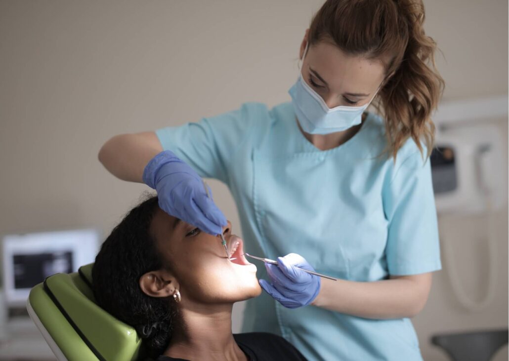 Dentist examining a patient's tooth before an extraction, explaining how long a tooth extraction procedure typically takes.