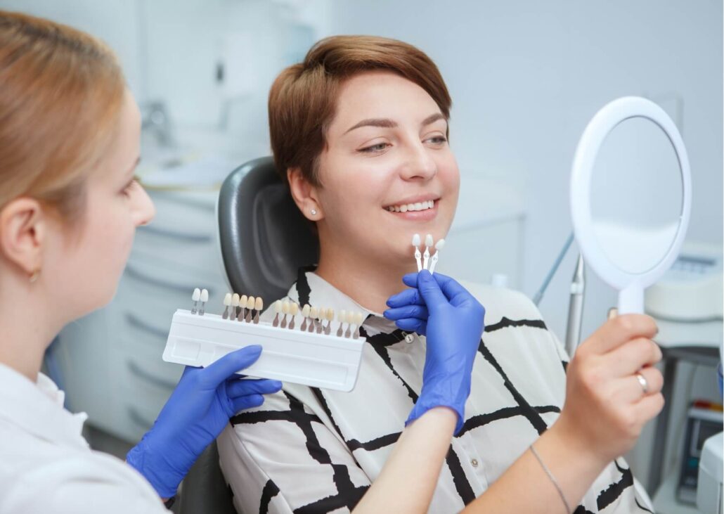 Patient comparing tooth shades with a dentist during a professional teeth whitening consultation