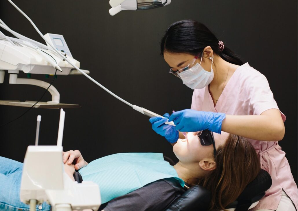 Dentist examining a patient to explain how long it takes for a tooth to grow back after tooth loss or extraction.