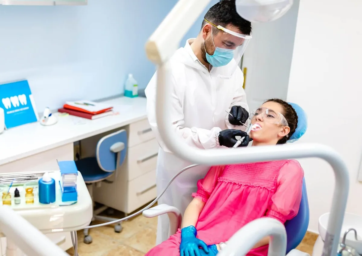 Dentist examining a patient’s mouth for discolored teeth.